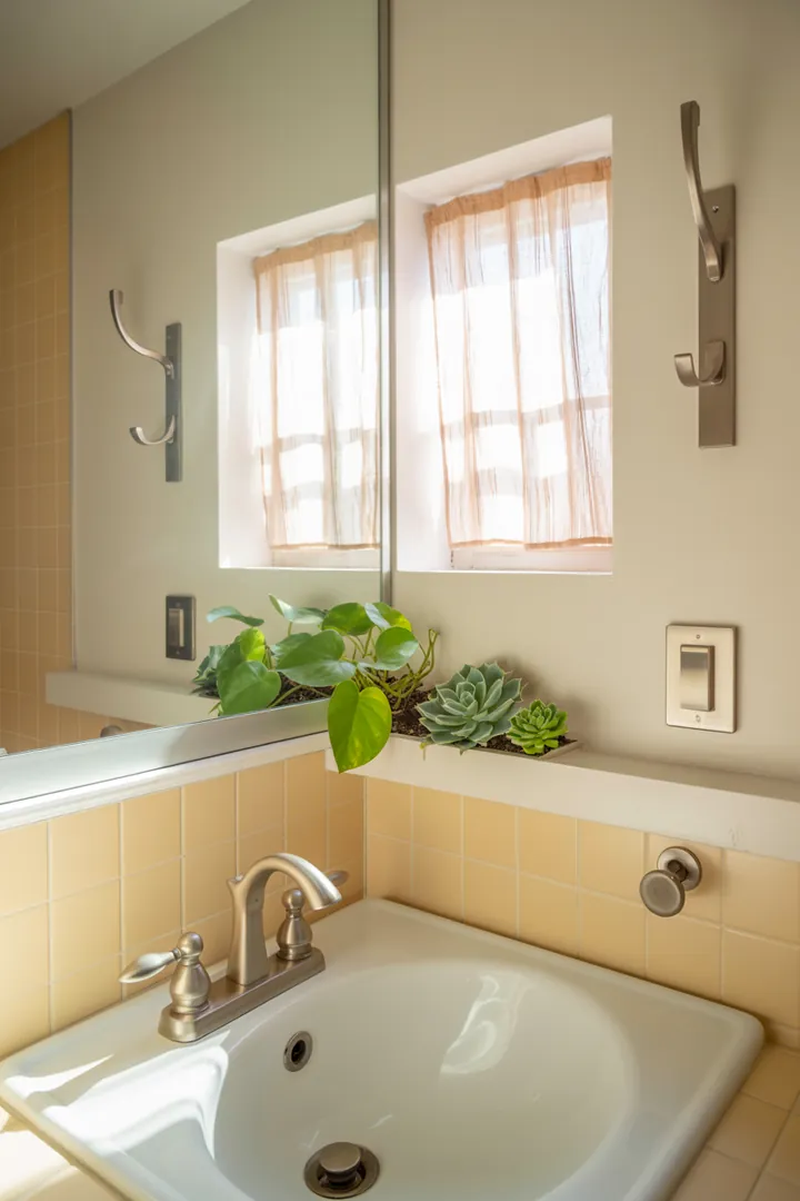 Eine stilvolle Umgestaltung eines kompakten Badezimmers mit modernen Möbeln, hellen Farben und cleveren Lösungen, um den Raum großzügiger wirken zu lassen.