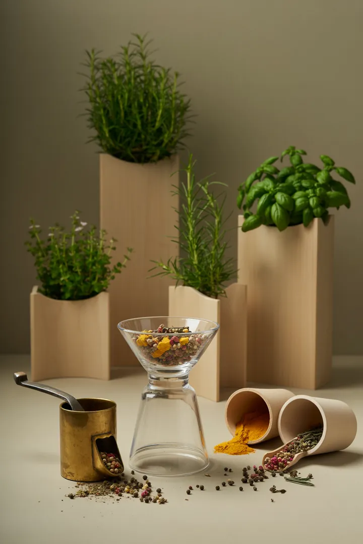 Ein praktisches Set zur Gewürzorganisation, bestehend aus einem Dosierlöffel, einem Gewürztrichter und passenden Gewürzdosen, alles auf einer sauberen Auffangschale angeordnet.