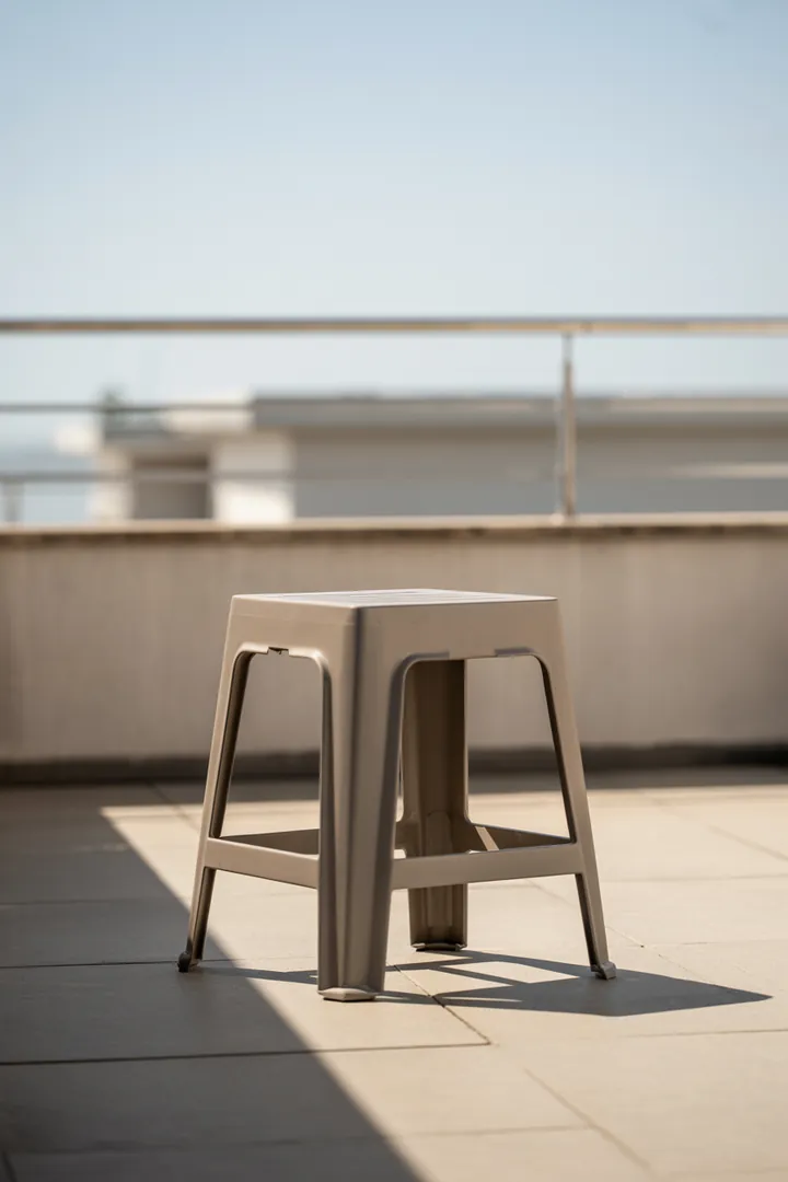 Balkonhocker als flexibles 3-in-1-Möbel (Sitz, Fußablage, Ablage), am besten wetterfest und leicht zu verstauen, aber bei Wind sicher genug.