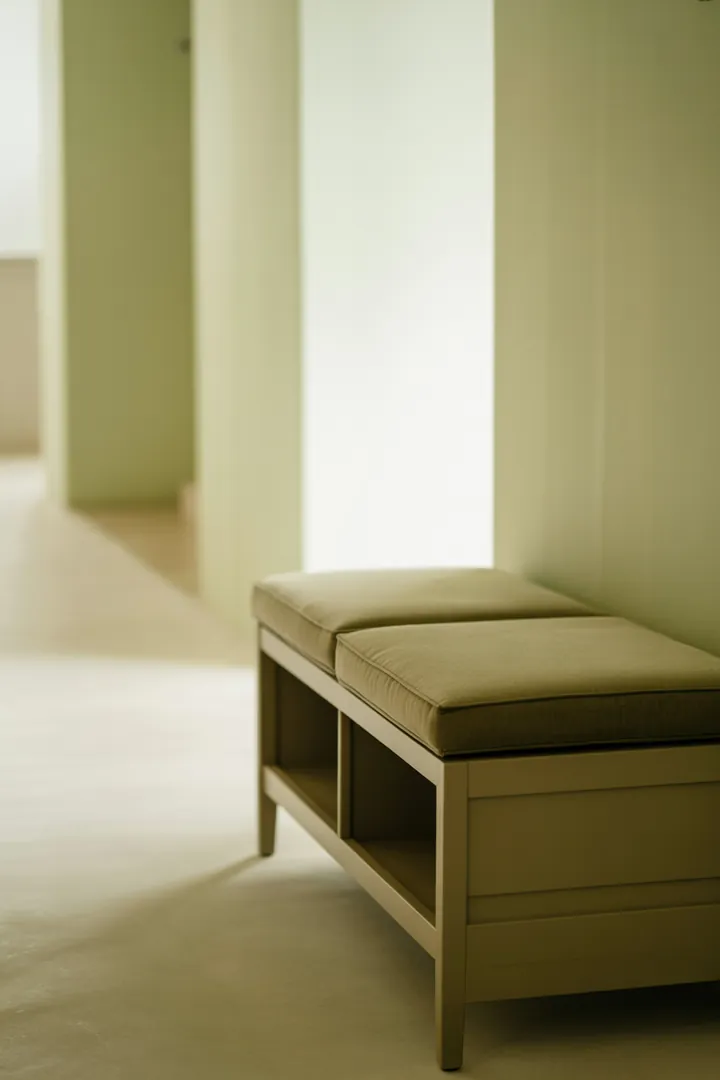 Sitzbank mit Stauraum im Flur als kombinierter Sitzplatz und Ordnungslösung für Schuhe und Alltagskram.
